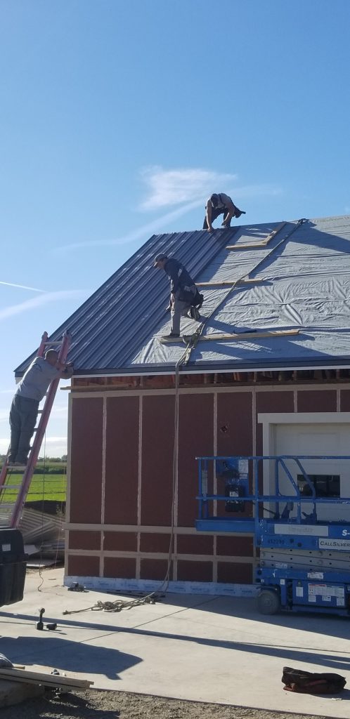 men installing metal roof